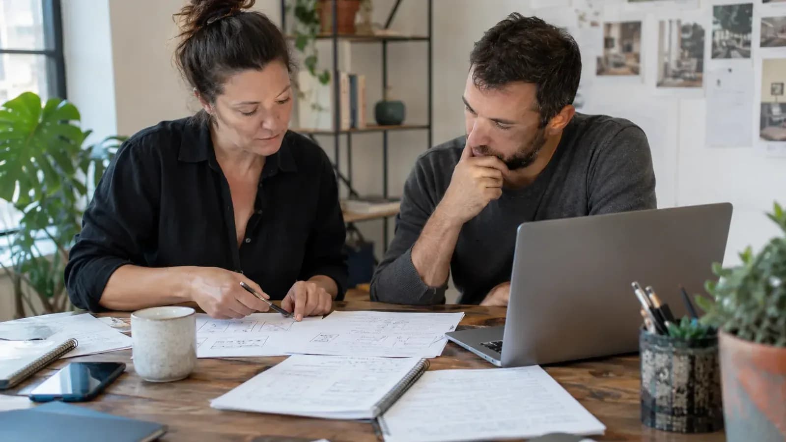 Kurumsal web sitesi projesinden önce kâğıt taslakları ve içerik notlarını inceleyen işletme sahibi ile danışman
